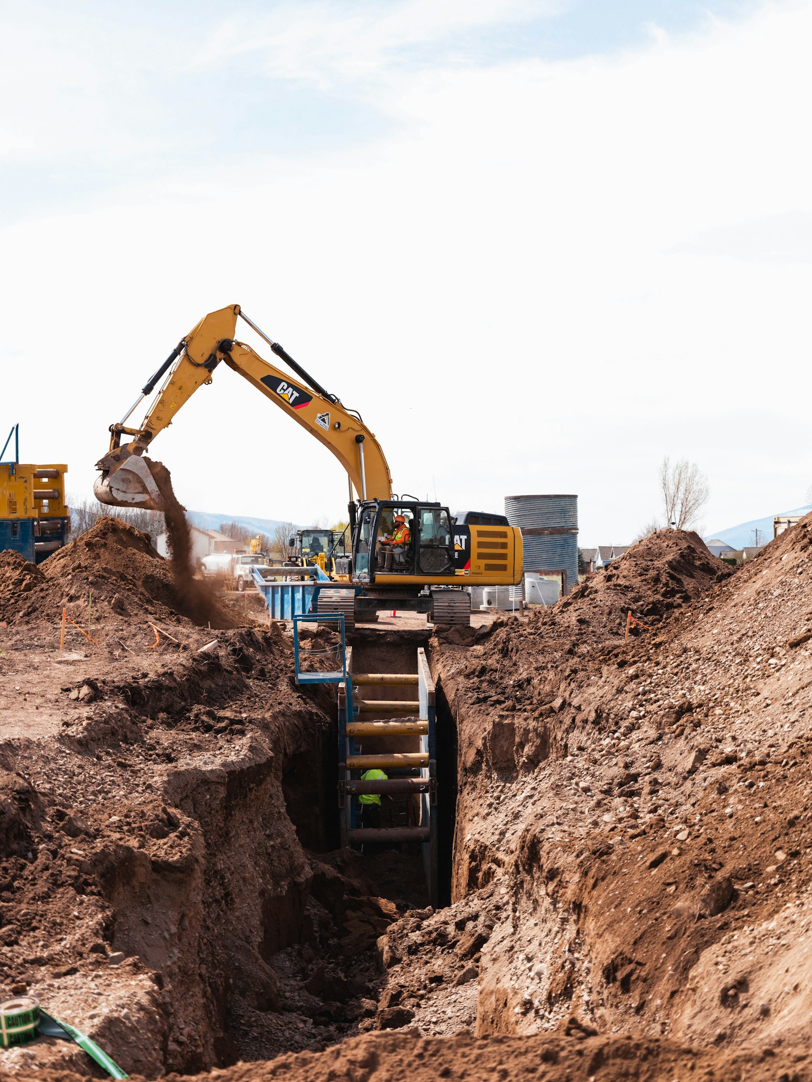 Excavator working in a deep construction trench